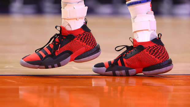 View of Trae Young's red and black adidas shoes.